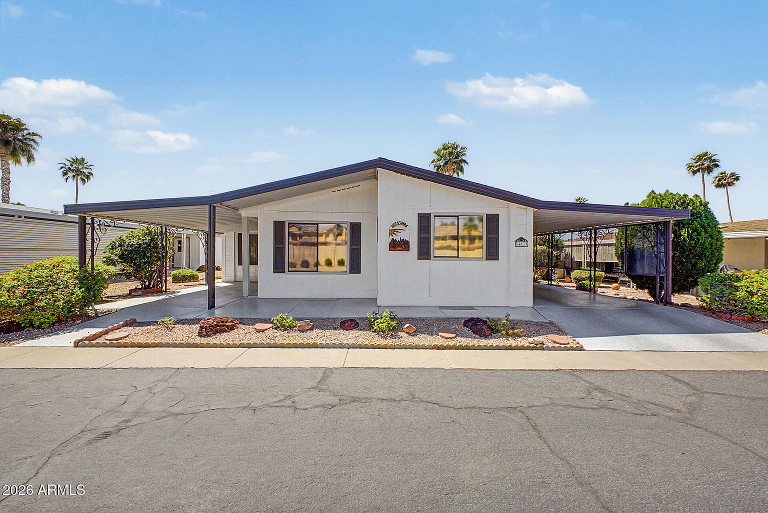 Front exterior and covered porch of the manufactured home for sale at 6209 E McKellips Rd #463 in Palmas del Sol 55+, Mesa AZ
