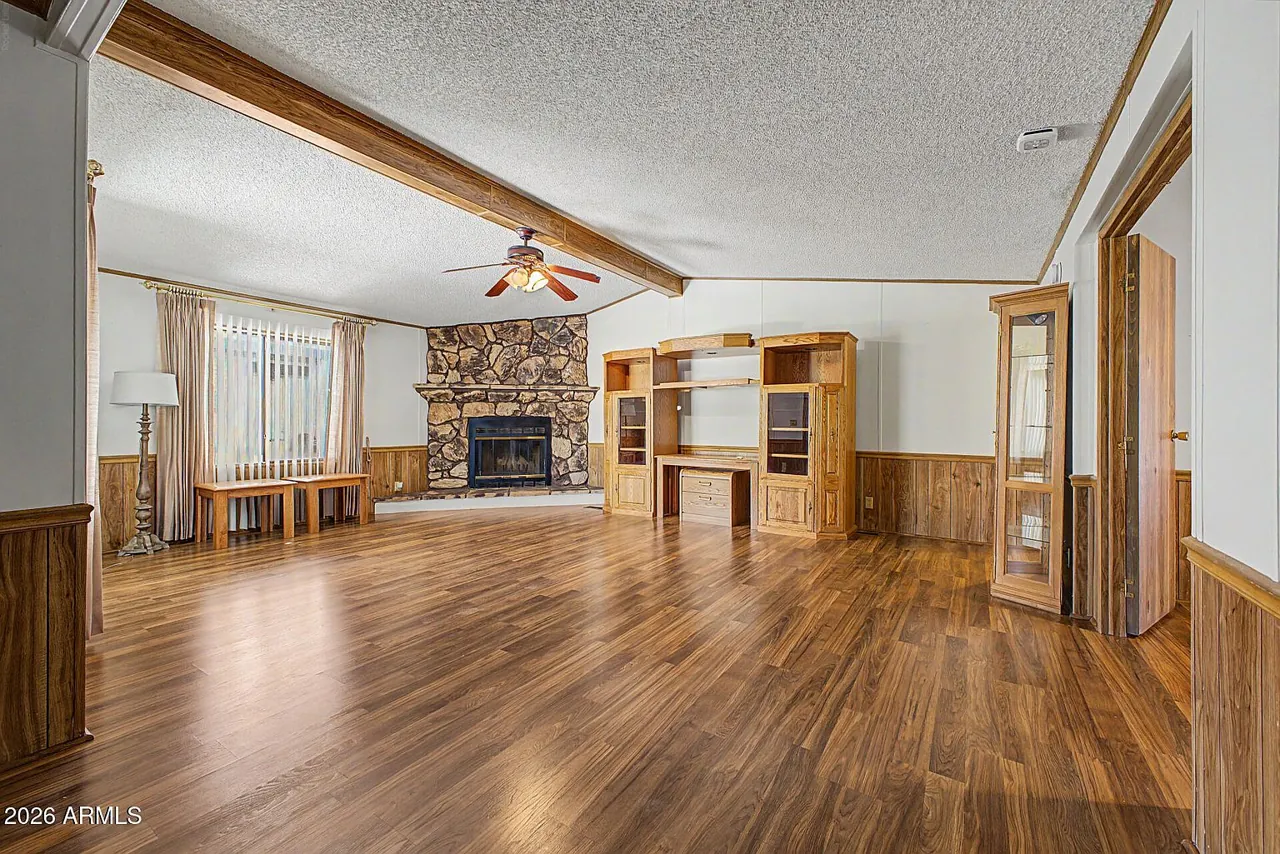 Vaulted-ceiling living room with corner fireplace and hickory laminate floors