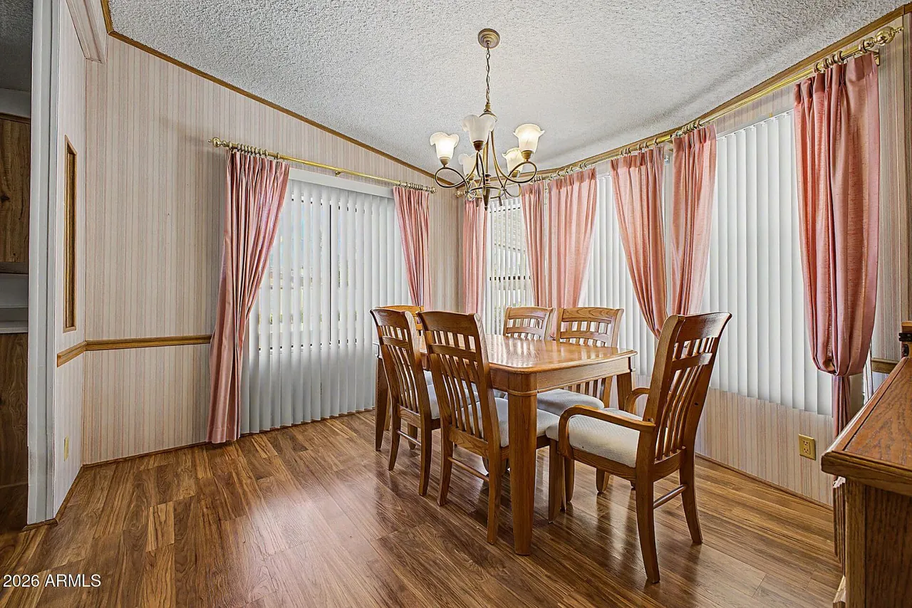 Sunlit dining room with chandelier and large window