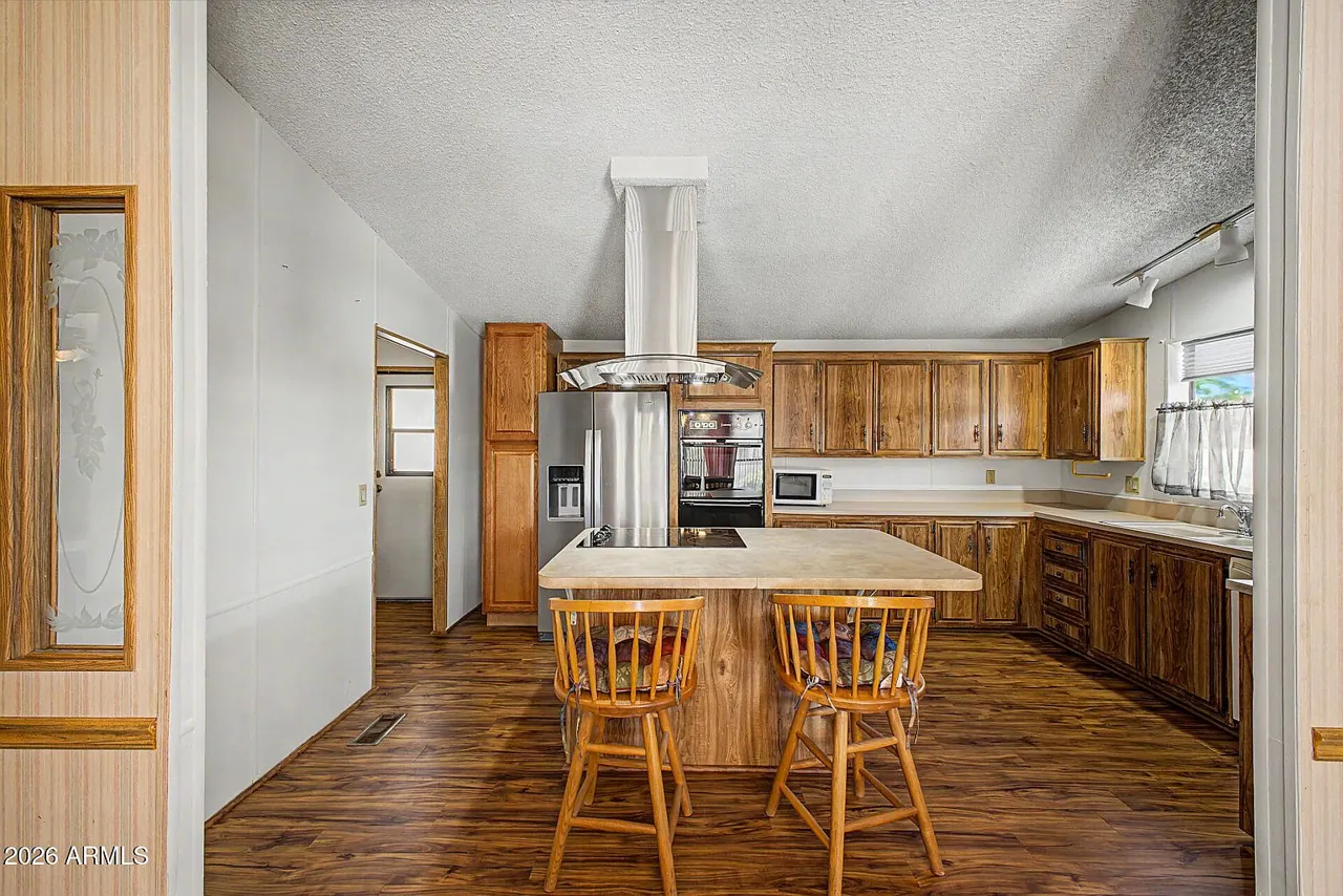 Island kitchen with breakfast bar and wood cabinetry