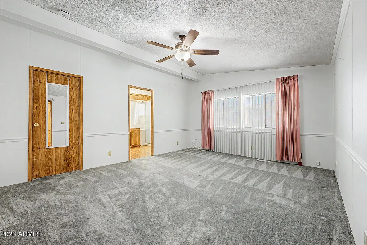 Primary bedroom with carpet and ceiling fan