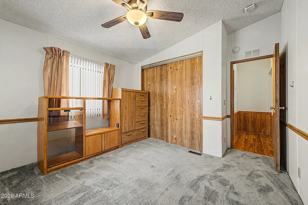 Third bedroom with mirrored closet doors and laminate floor